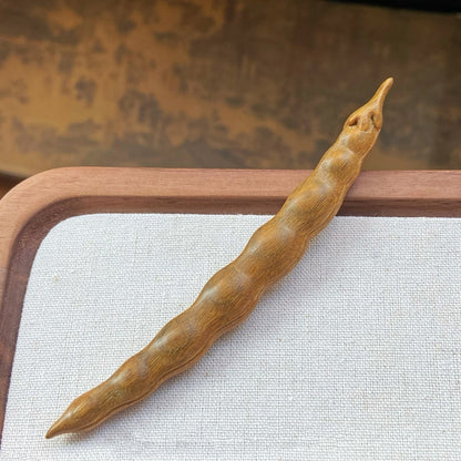 Close-up of yellow-green sandalwood wooden hair stick with smooth finish
