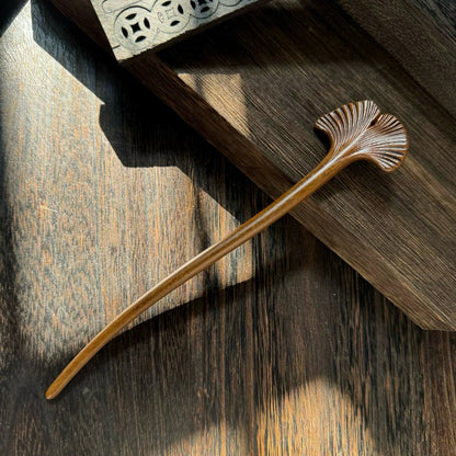 A single Tatajuba wood hair stick featuring a beautifully carved ginkgo leaf design at the top.
