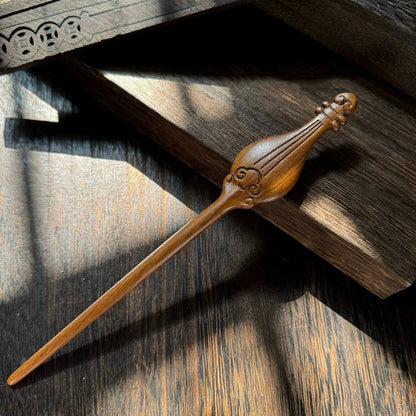 A hand-carved Tatajuba wood hairpin with a pipa (lute) shaped top and engraved cloud details.