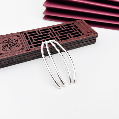 A sleek four-prong updo hair pin shown in a silver-tone finish on a white background.