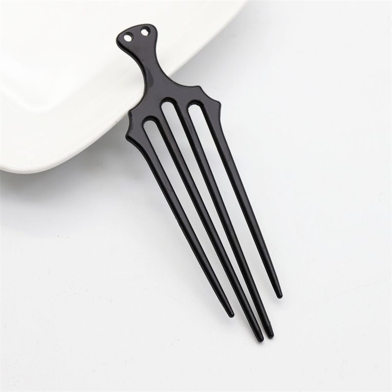 A single black vintage-style trident hair fork with four prongs for securing updos.