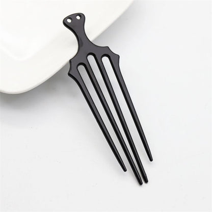 A single black vintage-style trident hair fork with four prongs for securing updos.