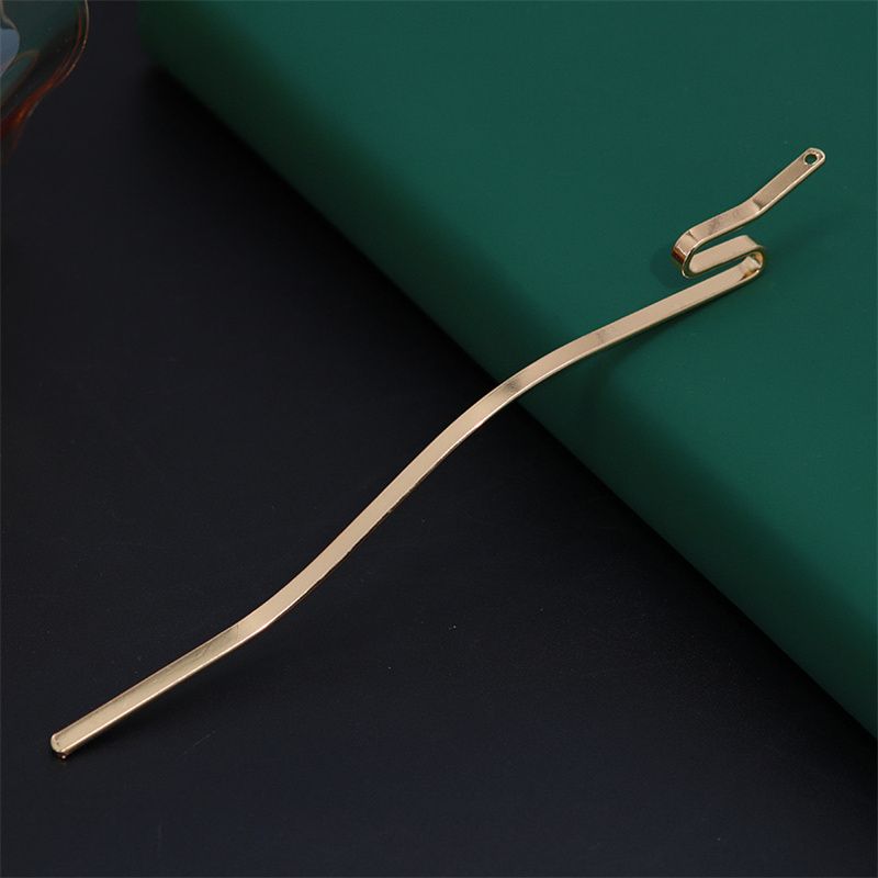 Close-up of the folded, pierced top of a serpentine hair stick, showing the hole for adding charms.