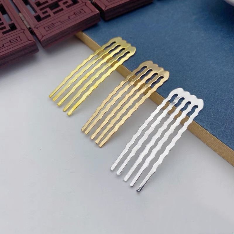 An assortment of small wavy five-prong hair combs in gold, light gold, and silver finishes.
