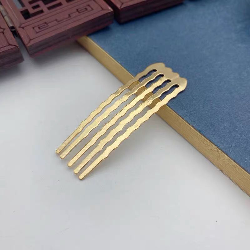 A small gold metal side comb with wavy tines for a secure, non-slip grip in hair.