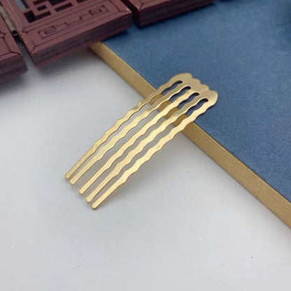 A small gold metal side comb with wavy tines for a secure, non-slip grip in hair.