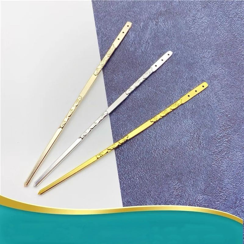 Set of silver and gold engraved hair sticks arranged on gradient surface, versatile for DIY hair accessory essentials.