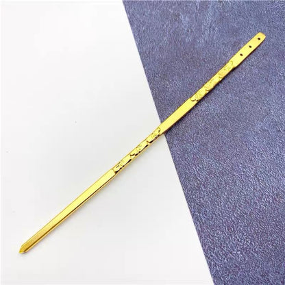 Gold alloy hair stick with intricate engravings, showing pointed tip and textured surface ideal for handmade hairstyle projects.