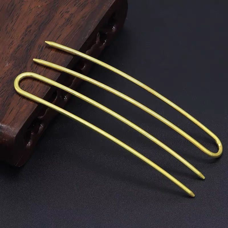 Close-up of gold 105mm U-shaped hair pin with arched prongs, showcasing fine craftsmanship for handmade updos.
