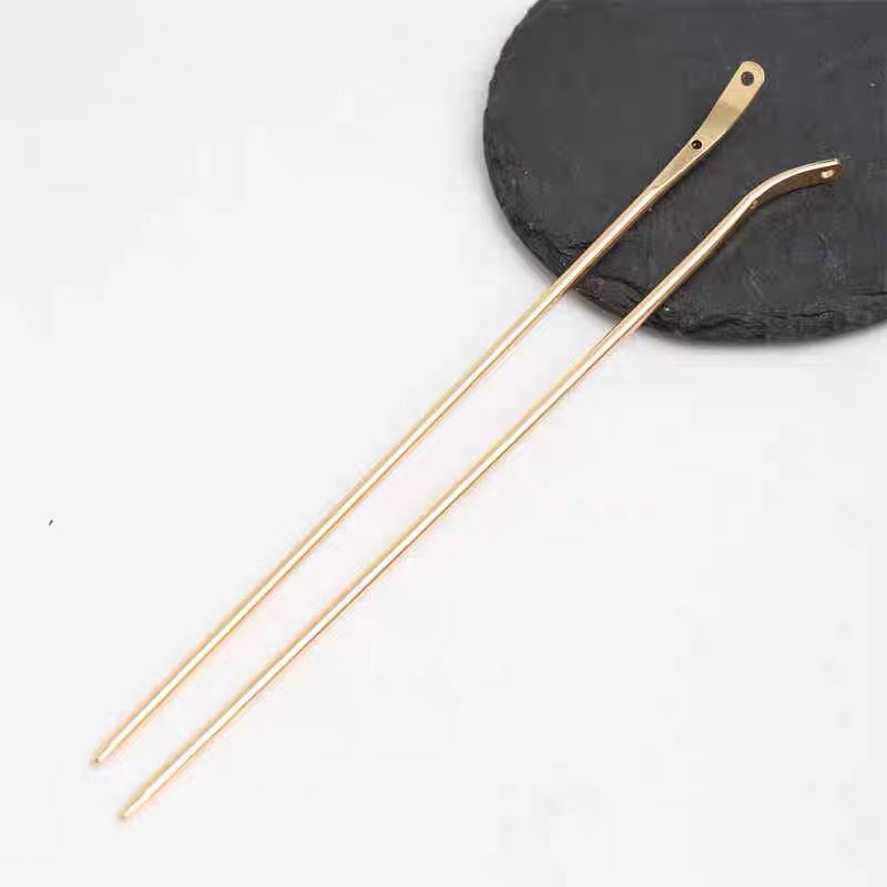 Close-up of the polished finish and charm hole on the gold alloy bent hair stick blank.
