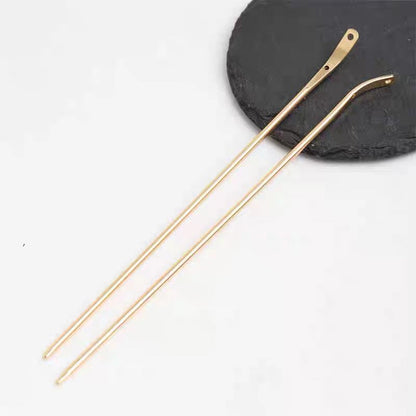 Close-up of the polished finish and charm hole on the gold alloy bent hair stick blank.