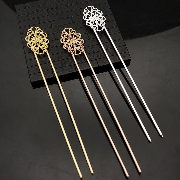 Set of 3 Chinese-style copper hair sticks with intricate floral filigree tops in gold, rose gold, and silver tones, displayed on black brick background
