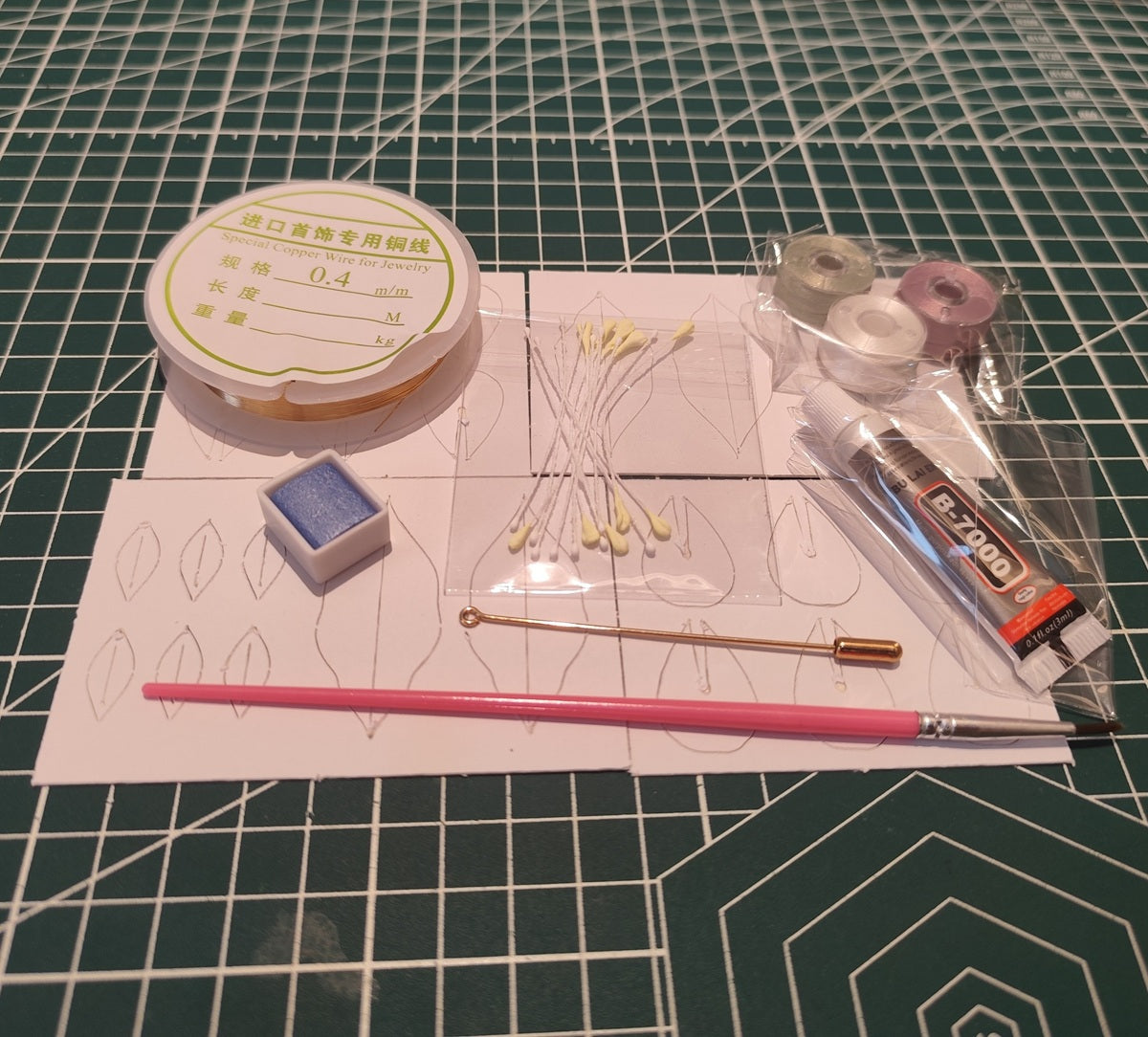 DIY flower craft supply kit including threads, wire, glue, blue shading powder, brush, and templates for making a Statice flower.