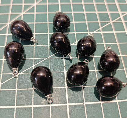 Group of glossy black plastic tear drop pendants with silver-tone findings for DIY jewelry supplies.