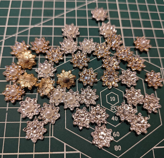 Assortment of DIY Craft Supplies Snowflake Charms (Gold & Silver, Pearl & Rhinestone Centers) on Cutting Mat