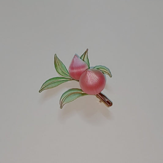 Handcrafted Chanhua peach hair clip featuring pink thread-wrapped peaches and green leaves on a light background.