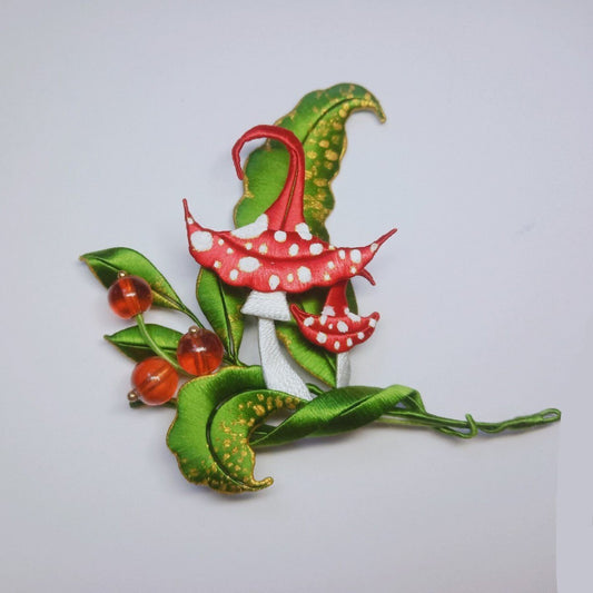 3D botanical pin depicting a mushroom and berry forest scene made with traditional artisanal thread-wrapping.