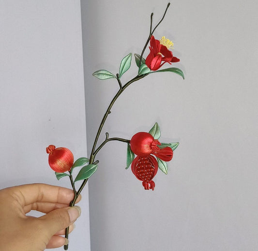 Handcrafted Chanhua thread-wrapped pomegranate branch featuring a red flower with yellow stamens and multiple red fruits with green leaves.