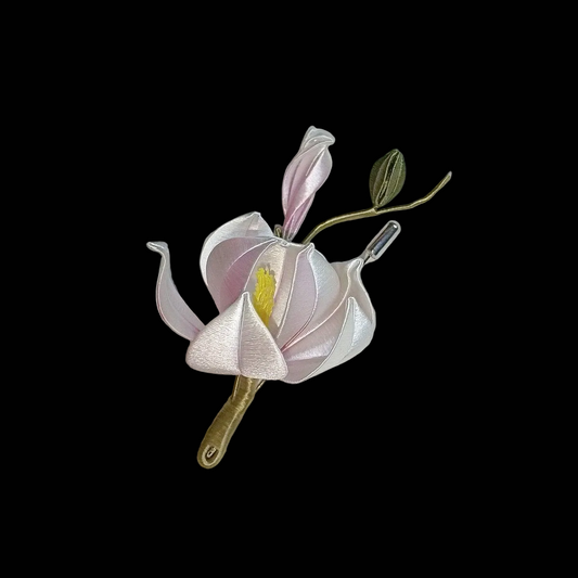 Handcrafted Chanhua magnolia flower brooch in white and pale pink with green leaves and yellow stamen.