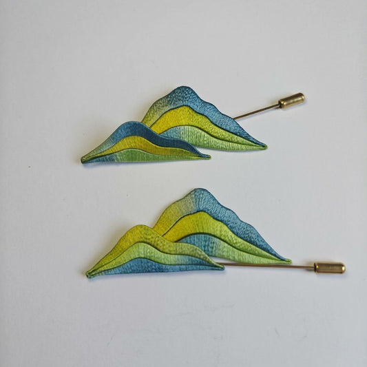 3D thread-wrapped landscape pin depicting traditional blue-green mountains made with intricate artisanal techniques.