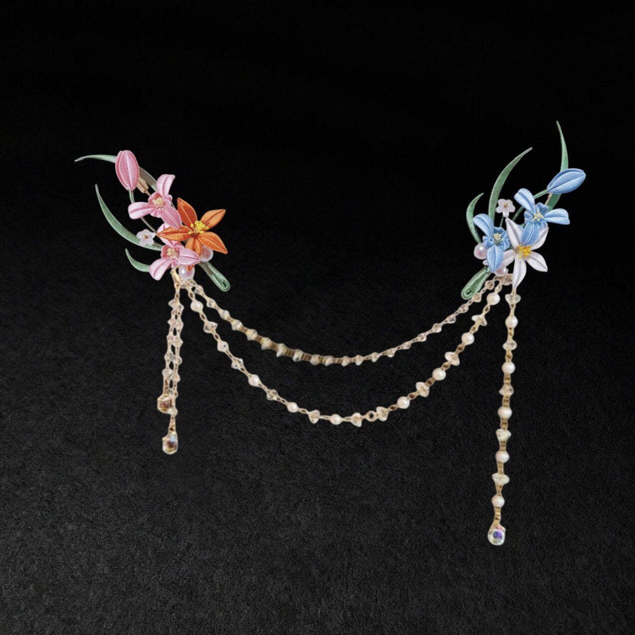 Chanhua handmade dual flower brooch set in warm and cool color options, connected by a draped pearl and crystal chain, displayed on a dark background