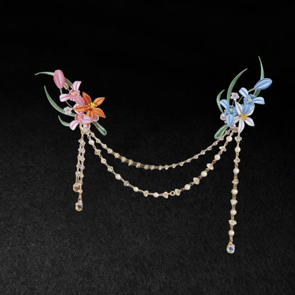 Chanhua handmade dual flower brooch set in warm and cool color options, connected by a draped pearl and crystal chain, displayed on a dark background