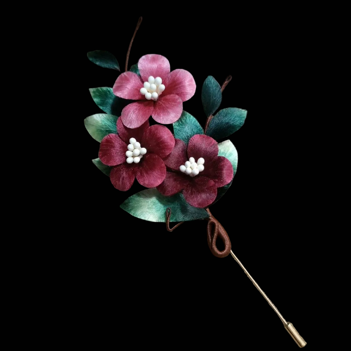 Close-up of pink and red silk velvet flowers with white beads and green leaves on Ronghua brooch