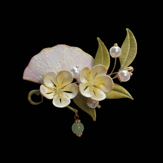 Handcrafted Chanhua brooch featuring a thread-wrapped shimmering folding fan, white flowers, and green leaves with pearl accents.