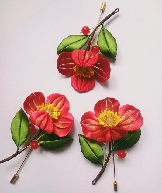 3D floral pin depicting blooming red poppies made with intricate artisanal thread-wrapping techniques.