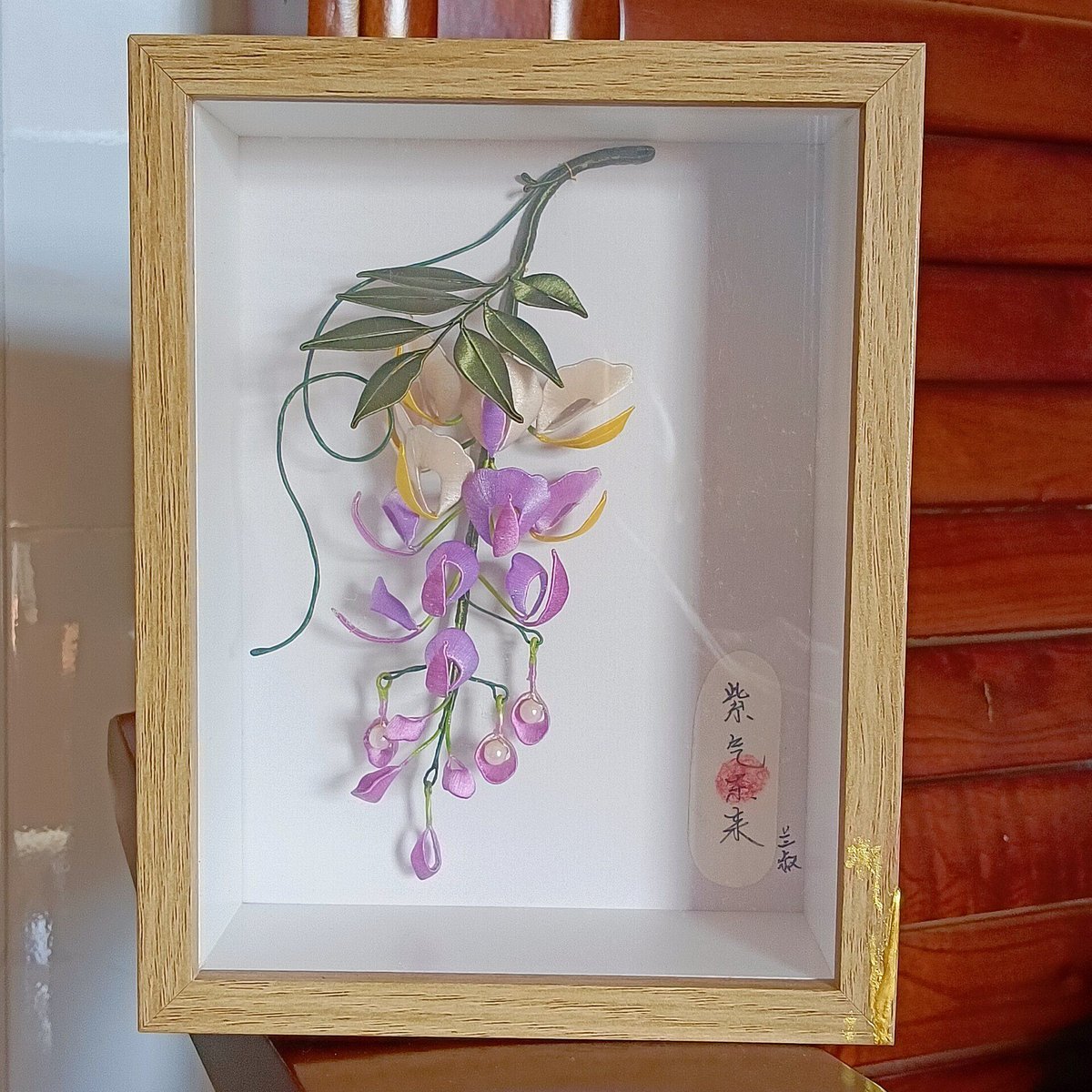 Luxury 3D embroidery floral decor with artisanal silk-thread wisteria blossoms in a shadow box for home interior design.