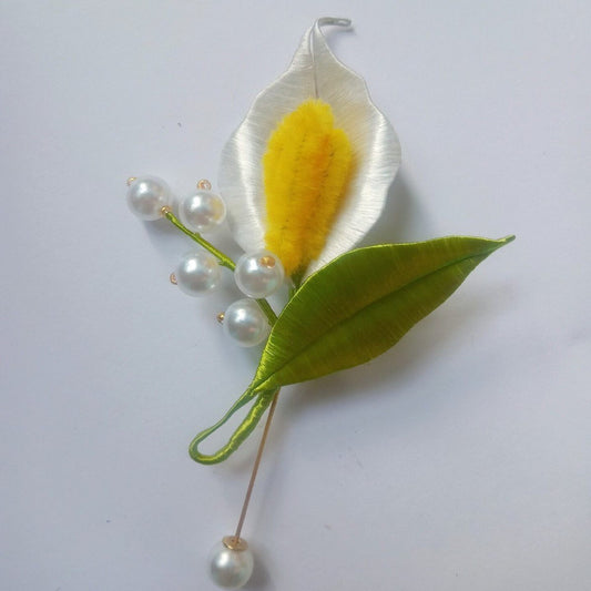 3D floral pin depicting a blooming Calla Lily made with intricate artisanal thread-wrapping techniques.