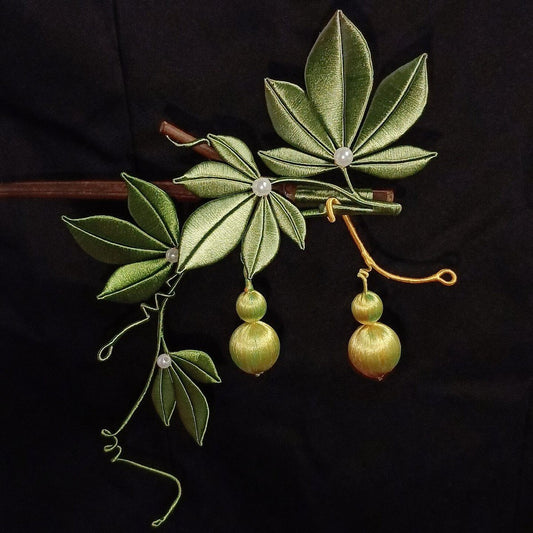 Handcrafted Chanhua thread-wrapped hairpin featuring green leaves, winding vines, and two golden-green gourds representing fortune and prosperity.