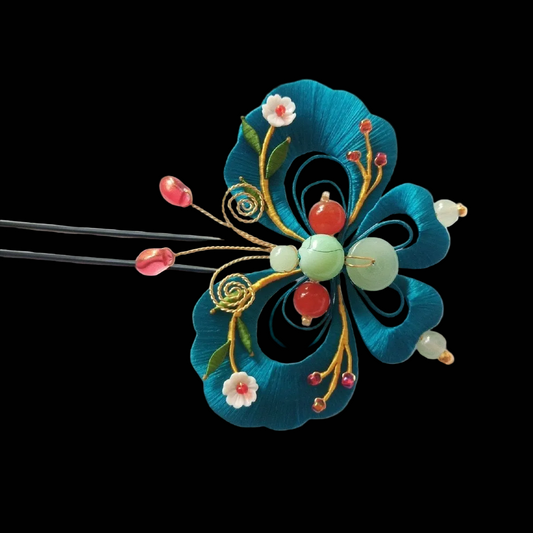 Handcrafted Chanhua butterfly hairpin featuring thread-wrapped teal wings with multi-colored bead treasures and small floral accents.
