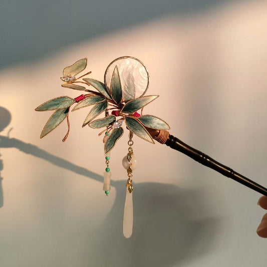 Ronghua handmade bamboo and butterfly hairpin with teal velvet leaves, gold edge trim, iridescent shell disc, crystal and jade pendants, and dark wooden pin, displayed on dark grey fabric