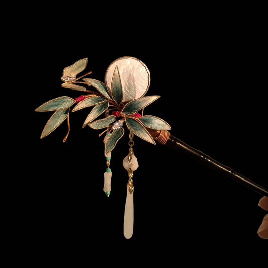Close-up of Ronghua bamboo butterfly hairpin showing teal velvet leaves with gold edge, shell disc, and crystal pendant detail