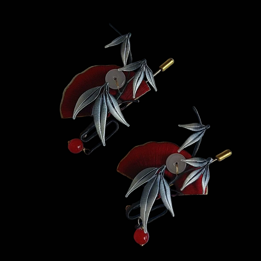 Handcrafted Chanhua brooch featuring a red thread-wrapped fan and silver-grey bamboo leaves with red bead accents.