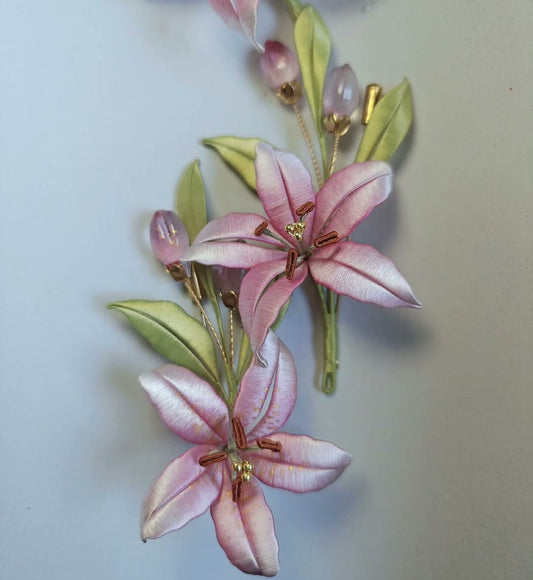 3D floral pin depicting a blooming pink lily made with intricate traditional thread-wrapping techniques.