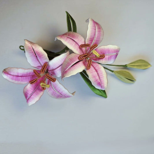 Luxury 3D embroidery floral pin depicting two blooming lilies made with intricate artisanal thread-wrapping techniques.