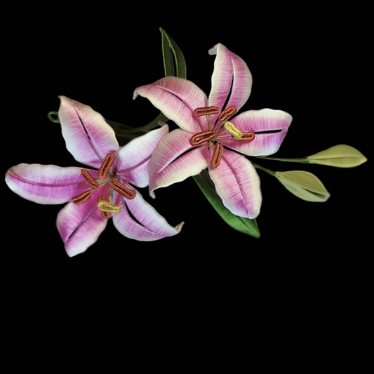 Handcrafted Chanhua dual lily brooch featuring pink and white thread-wrapped petals with green leaves and buds.