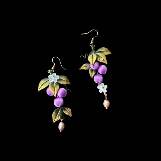 Close-up of Chanhua grape earring showing thread-wrapped purple grape cluster and gold-green leaf detail