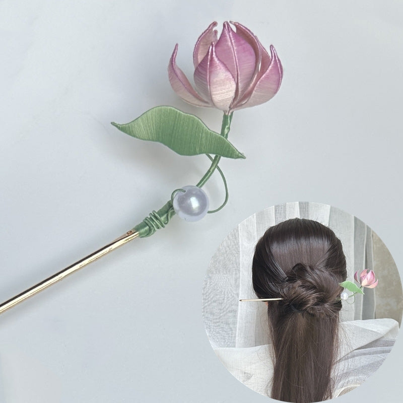 A handmade Chanhua hairpin with a pink silk-wrapped lotus flower and green leaf, shown on its own and worn in a woman's hair bun.