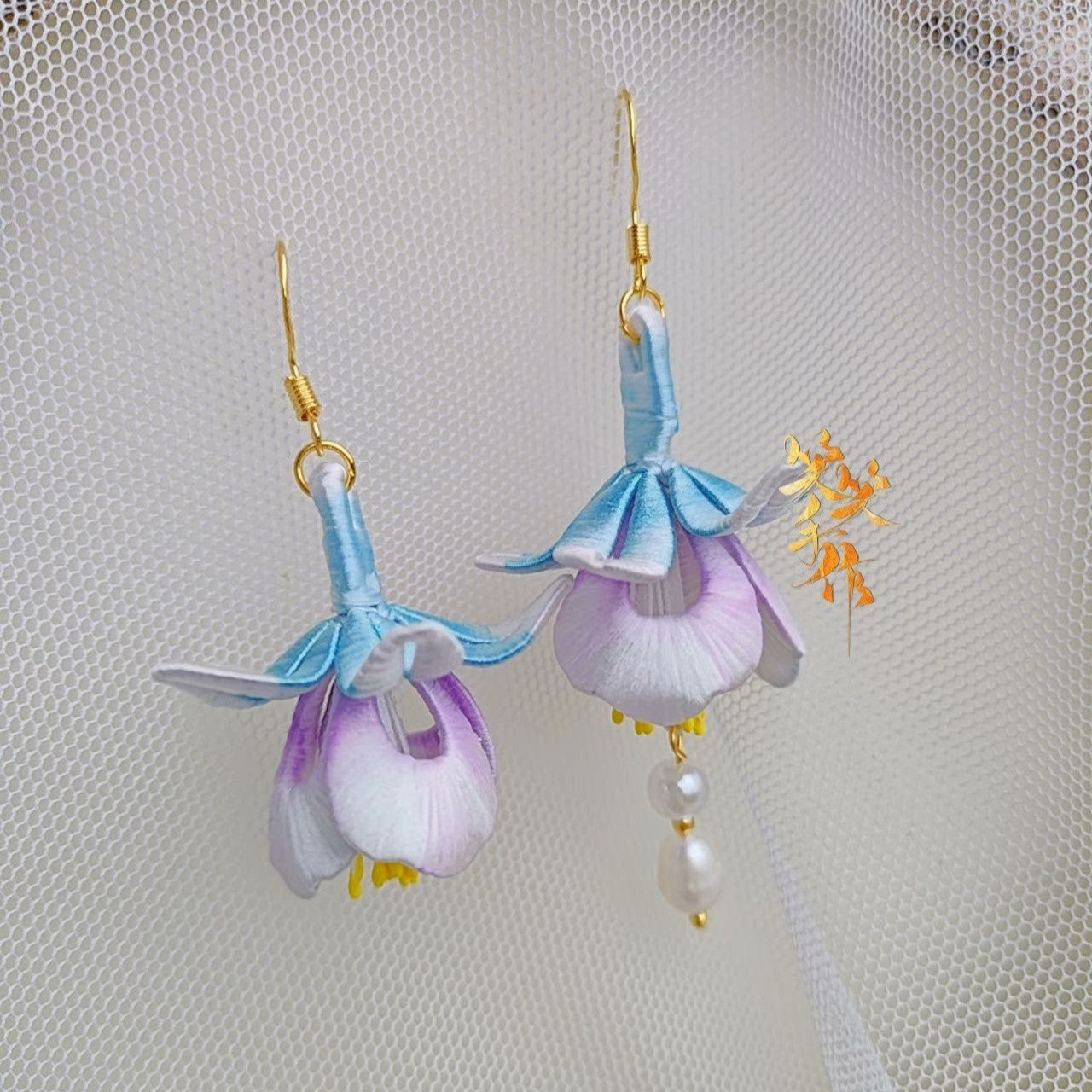Front view of the handcrafted Chanhua flower earrings with 925 silver hooks and freshwater pearls, presented on a white mesh surface, emphasizing their elegant design suitable for both daily and formal wear.