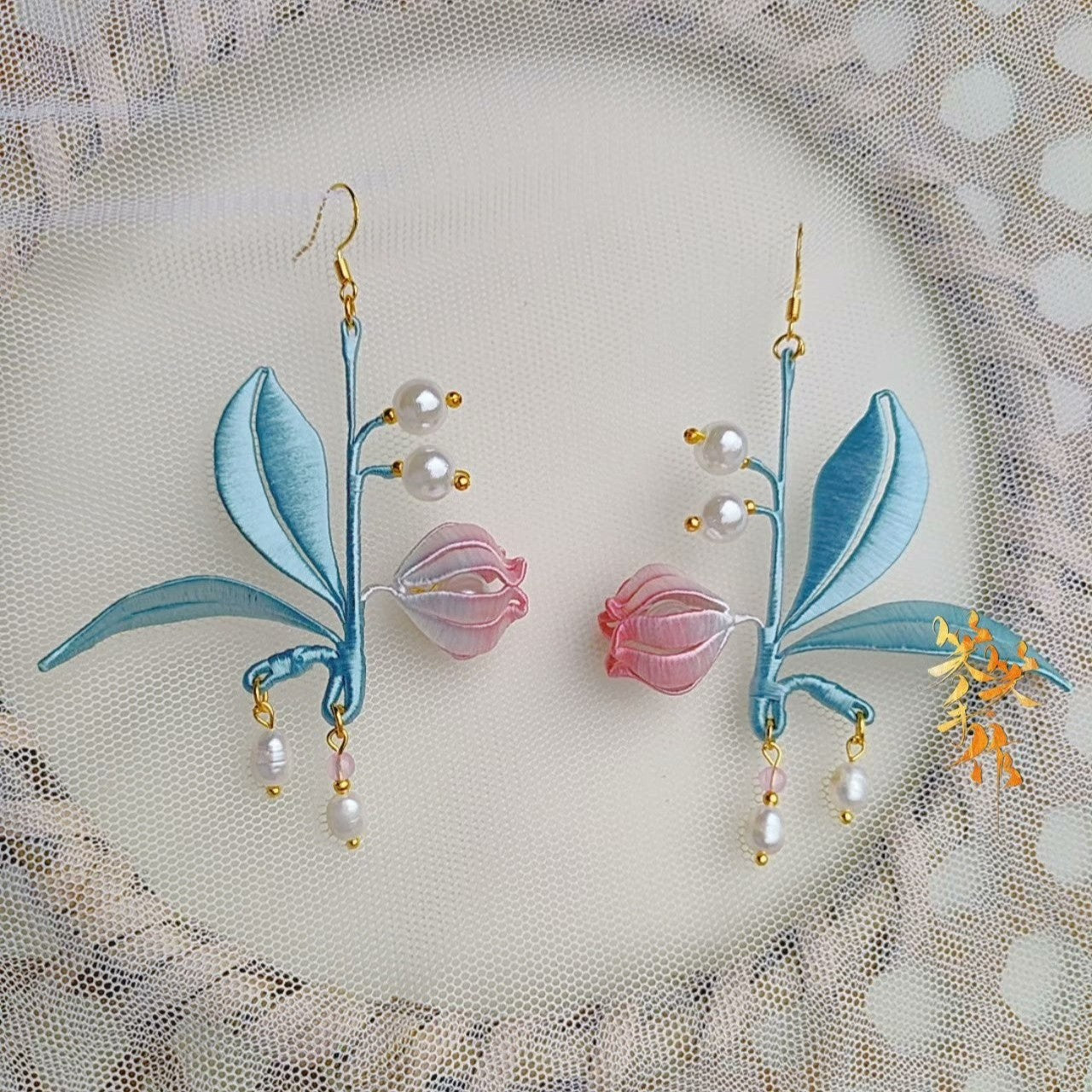 Handcrafted Chanhua orchid and pearl drop earrings featuring light blue leaves and pink buds, perfect for elegant occasions.
