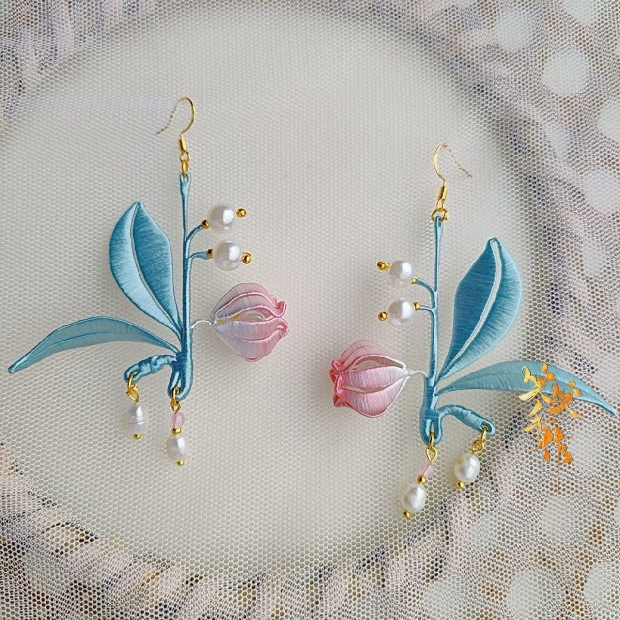 Pair of exquisite Chanhua embroidered earrings with delicate pink flowers and pearl accents, showcasing artisanal craftsmanship.