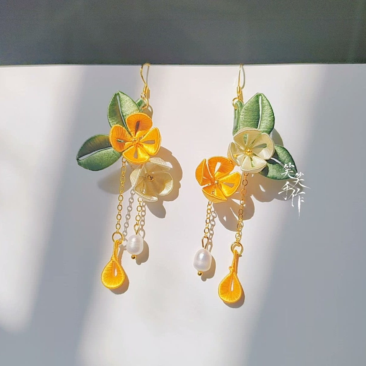 Elegant Chanhua fabric flower earrings with 925 sterling silver ear hooks and lustrous freshwater pearls, styled for a detailed product view.