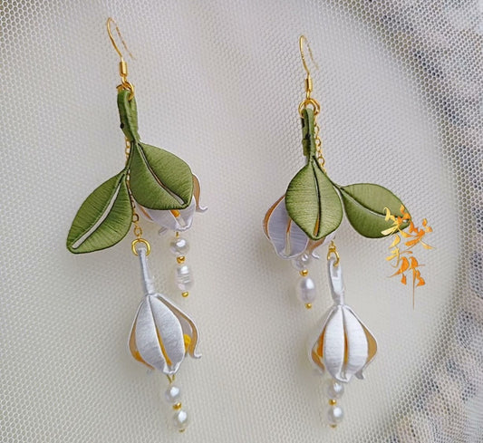 Pair of elegant Chanhua earrings featuring green silk leaves, white floral buds, and dangling natural pearls, ideal for both daily wear and events.