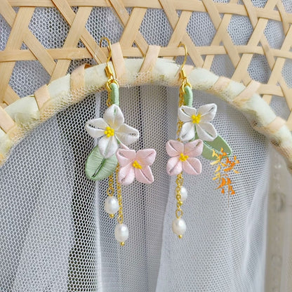 Close-up of a pair of artisan Chanhua floral earrings with 925 sterling silver hooks and natural freshwater pearls, displayed against a light background.