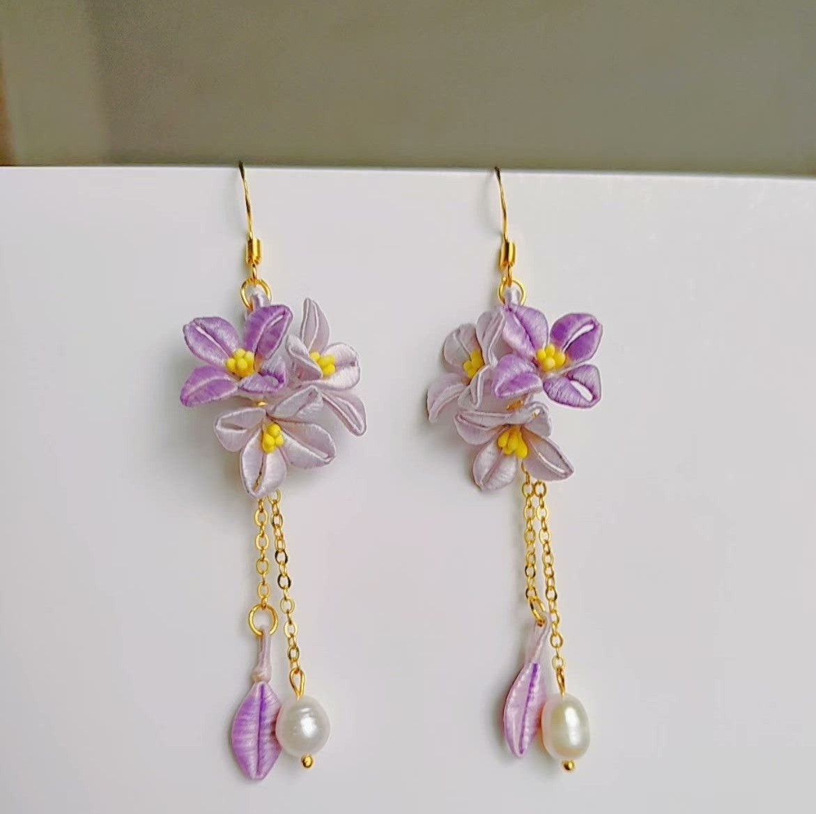 Artisan Chanhua fabric flower earrings in lavender purple, featuring gold-plated chains, 925 sterling silver hooks, and baroque freshwater pearls.
