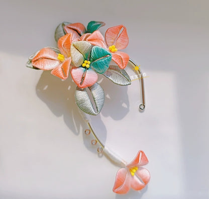 A single pure handmade Chanhua ear cuff with vibrant orange, teal, and grey silk flowers and leaves, showcasing intricate winding technique on a white background.