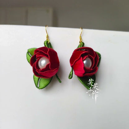 Close-up of handcrafted Chanhua rose earrings, highlighting the natural freshwater pearls and intricate ribbon work.